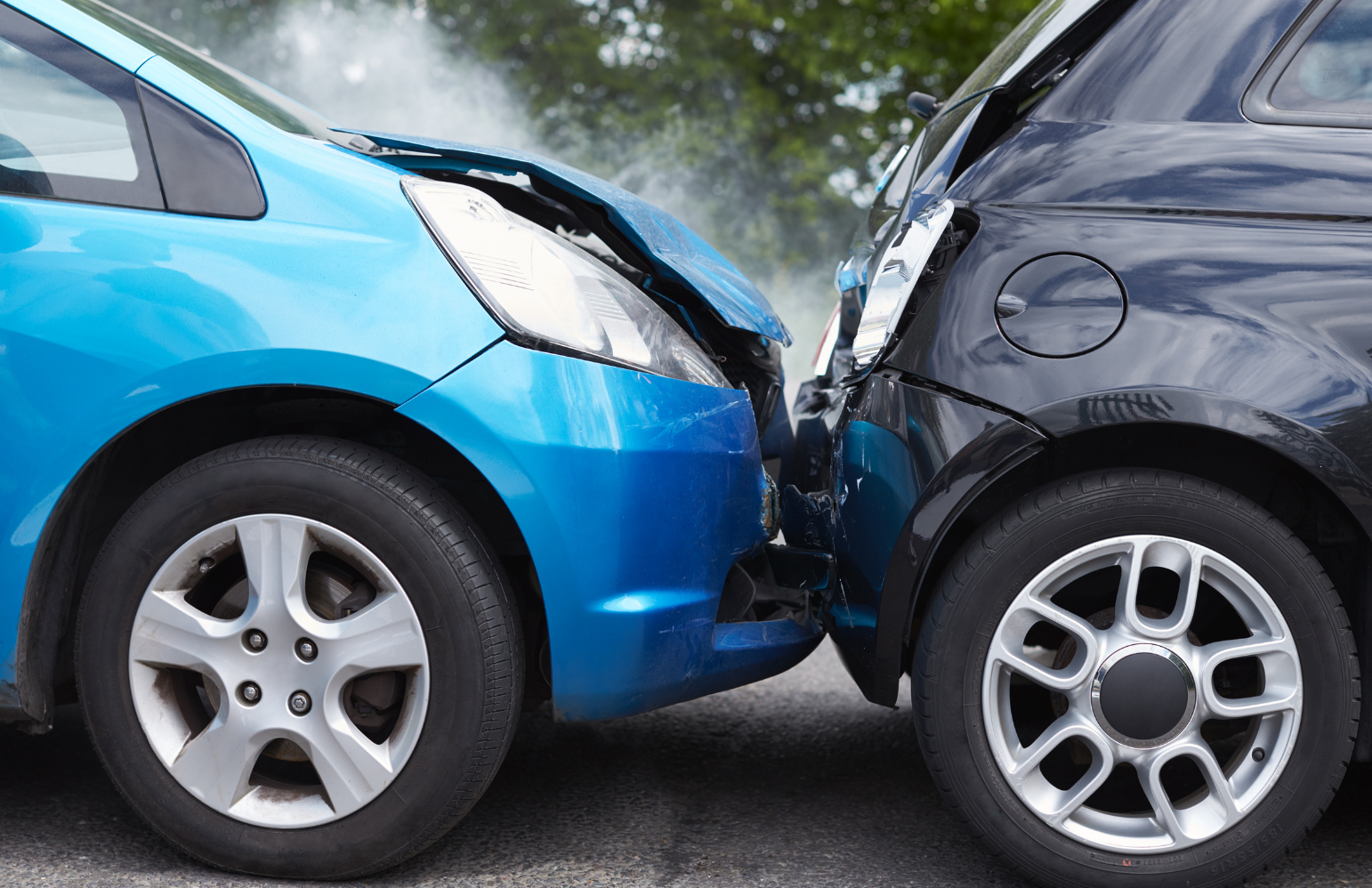 Two cars involved in a rear-end collision on a city street, showing visible front and rear damage.
